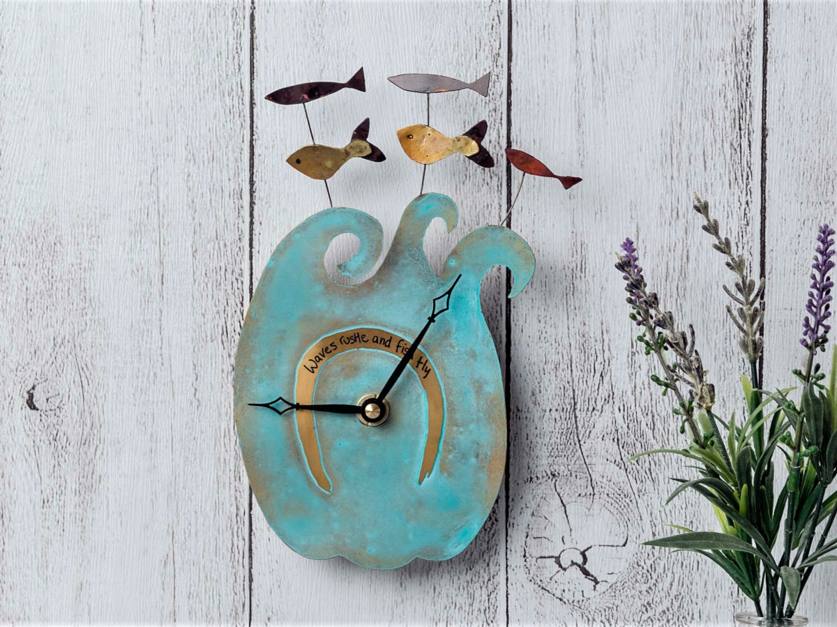 a blue clock on the wall with sea waves and flying fish